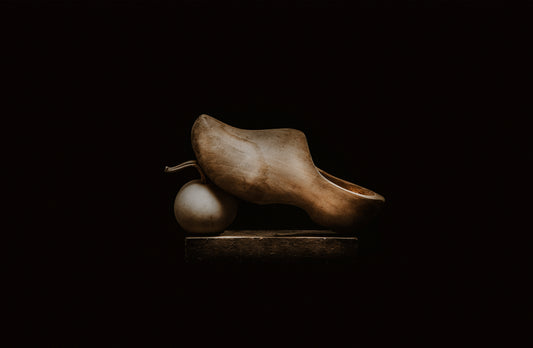 Chiaroscuro fine art photography of an antique Dutch clog on black background. Wabi-sabi luxury wall art by Struunt.
